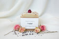 Artisan soap bar with a rose petal on top, branded as Ocean & Ivy Soap Co.