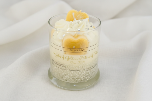 Candle in a glass jar with decorative elements and 'Ocean & Ivy' branding on a white background