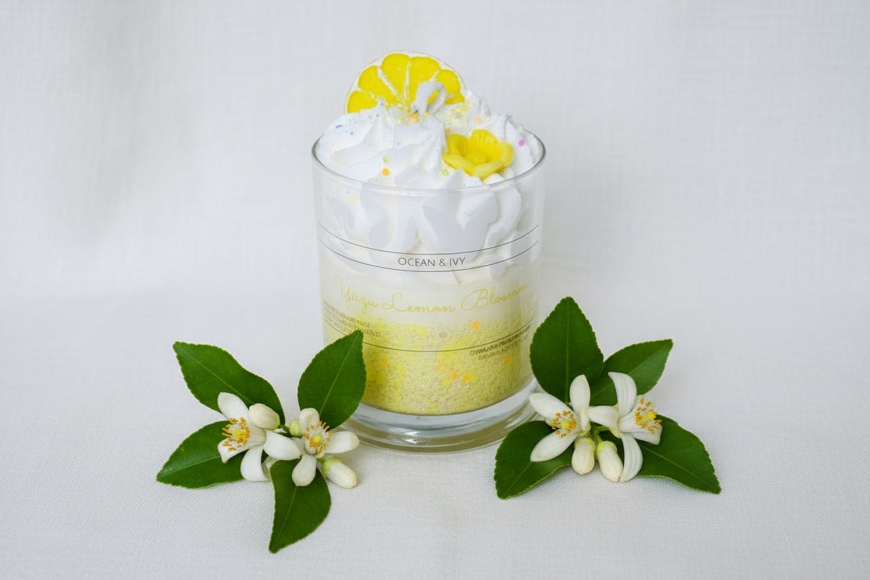 Glass candle with lemon slices and flowers on a white background